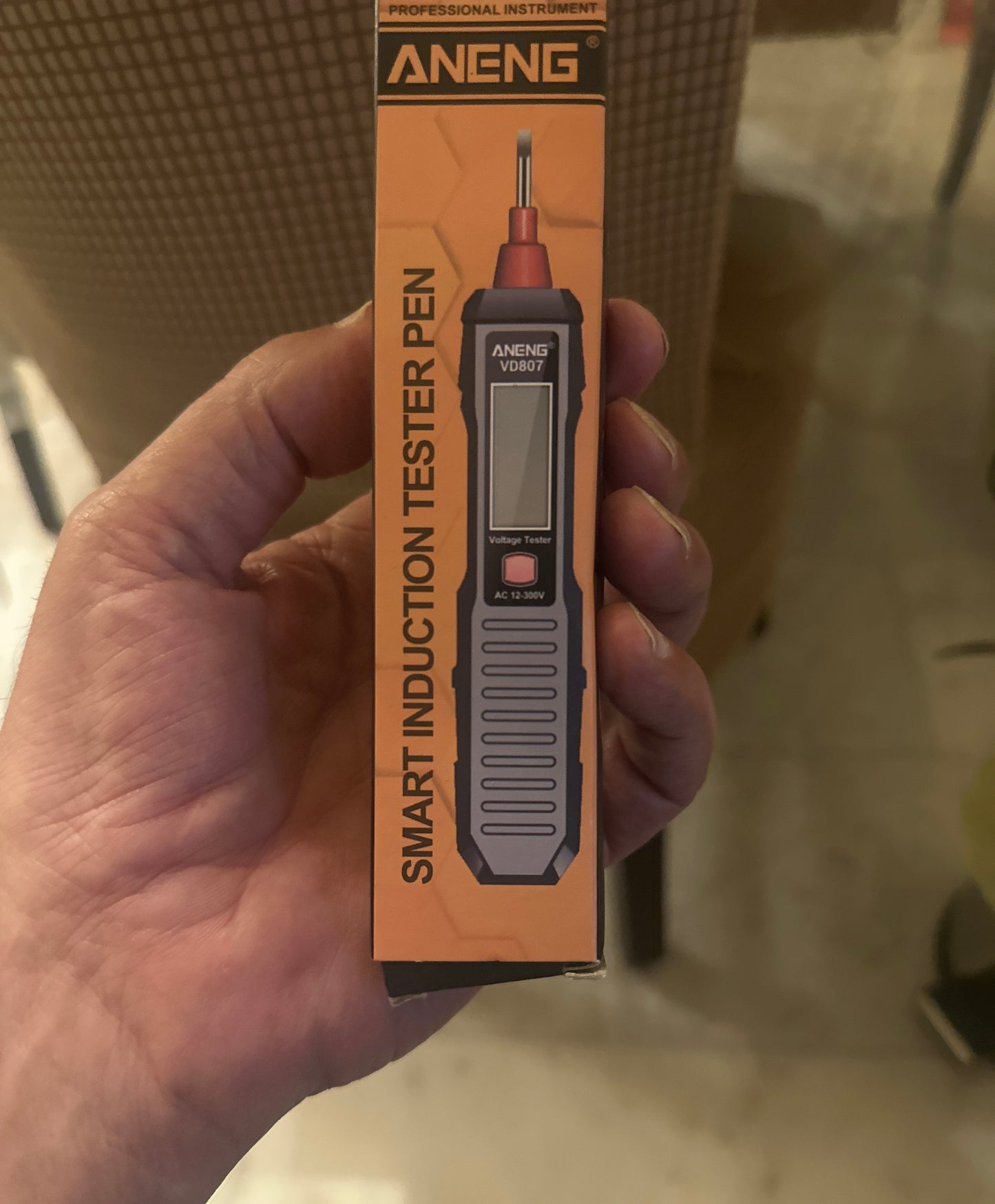 SHIMO/Smart induction tester pen packaging held by a hand with a blurred background
